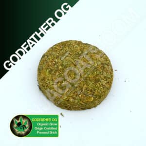 Close up photo of the pressed brick cannabis strain Godfather OG. Text next to the flower states the name of the strain, that it is organically grown, and pressed brick weed.