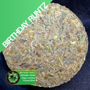 Close up photo of the pressed brick cannabis strain Birthday Runtz. Text next to the flower states the name of the strain, that it is organically grown, and pressed brick weed.